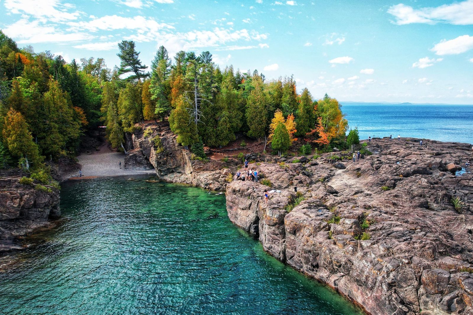 Breathtaking aerial shot of rocky coastline and forest at Presque Isle Park, Marquette, MI.